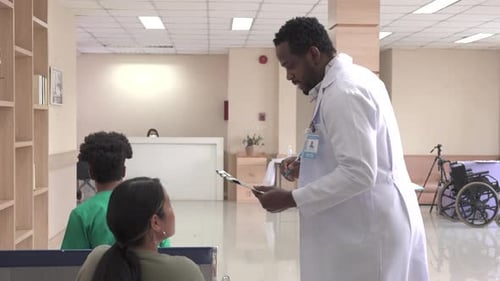 African doctor walk and hold clipboard through hospital hallway