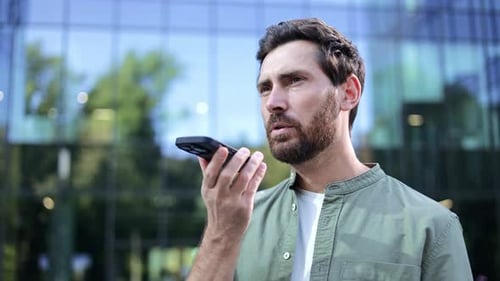 Man Uses Voice Command on Smartphone Outdoors
