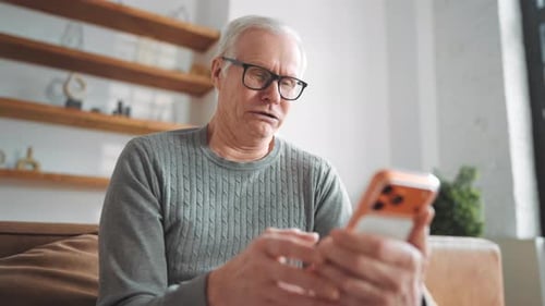 Senior Man Using Smartphone for Video Call at Home