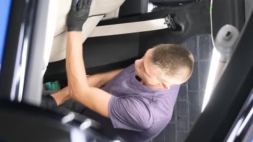 A Man Does Dry Cleaning of the Car Interior Vacuums the Car Interior Vertical Video