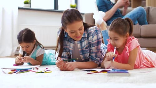Mother and Daughters Drawing Pictures Together Indoors