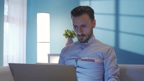 Focused Man Working on Laptop at Home