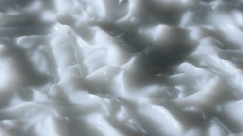 Close Up Shot of Cream Background Face or Body Cream Fluid Texture with Peaks Rotating Smooth