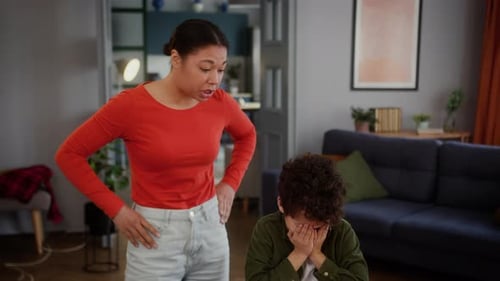 Frustrated Woman Scolding a Crying Boy Indoors