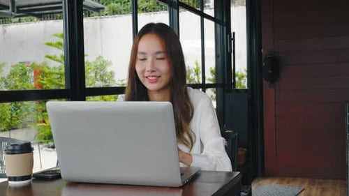 Asian Young Business Woman Lifestyle Using Laptop Computer at Cafe Coffee Shop