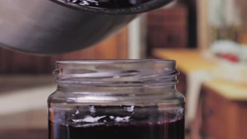 Pouring Fresh Homemade Jam into a Glass Jar