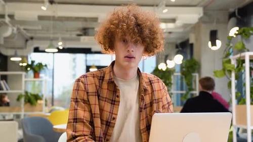Young Student Freelancer in Yellow Shirt Using Laptop in Coffee Shop Cafe Working Online Freelance