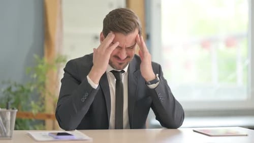 Stressed Man in Suit at Office Desk