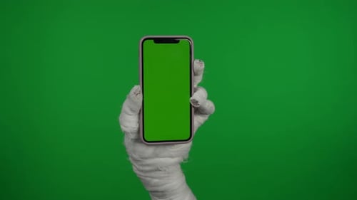 Detail Green Screen Isolated Chroma Key Video Capturing Mummy's Hand Holding a Smartphone with an