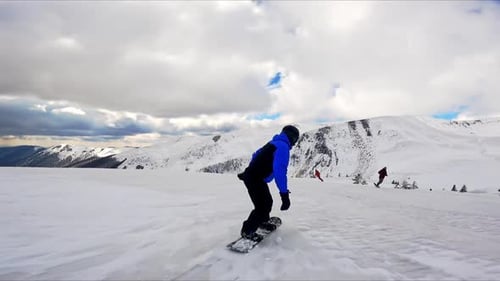 Snowboarder Glides Down Snowy Mountain Slope