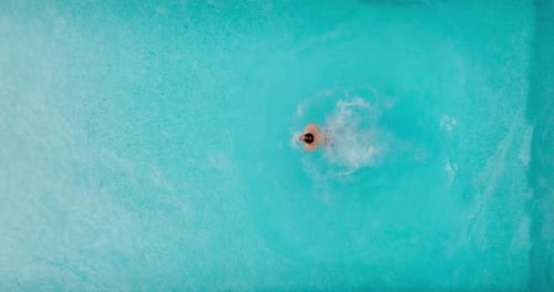 Aerial View As a Man Dives Into the Pool and Swims Slow Motion