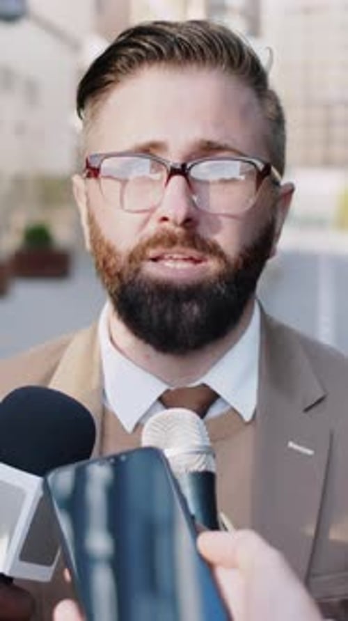 Man Being Interviewed by Reporters Outside