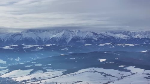 Aerial view of snowy mountain landscape in winter light
