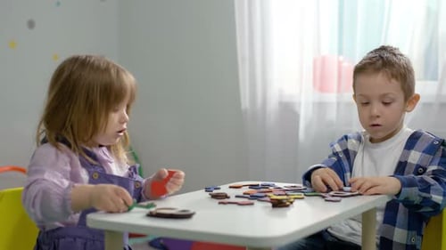 Children Play Logic Games at a Desk in Kindergarten