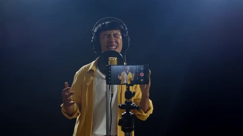 Young Adult Sings into Microphone in Studio