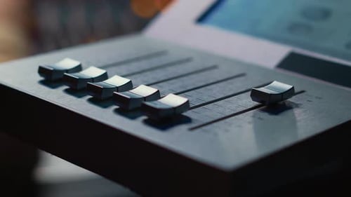 Sound Engineer Operating on Motorized Faders Controller in Professional Studio