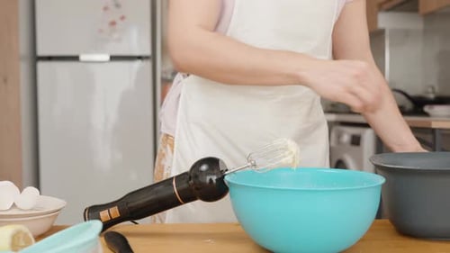 Ingredients on the table for the dough, a woman in the background of the kitchen interior is prepari