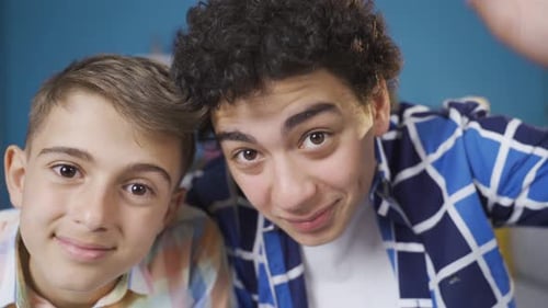 Two Cheerful Boys Waving and Posing Close Up