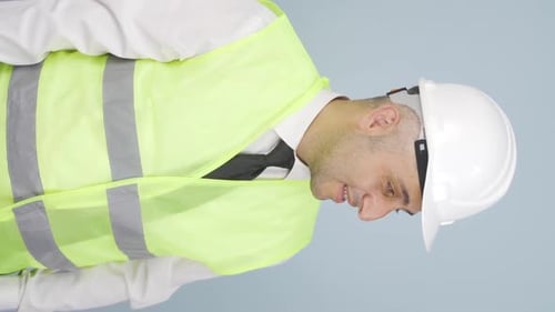 Vertikales Video eines Ingenieurs, der erstaunt in die Kamera schaut und eine Präsentation hält.