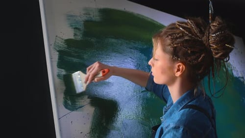 Woman Paints Abstract Art on Large Canvas