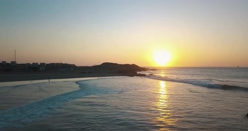 Surfing at sunset near Lobitos, Peru. Aerial orbiting