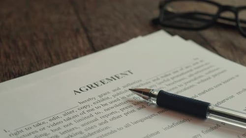 Agreement Lying on the Table with Glasses in the Background
