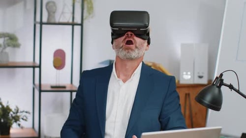 Mature Business Man in VR Goggles Watch Virtual Reality Video Working on Simulation Game at Office