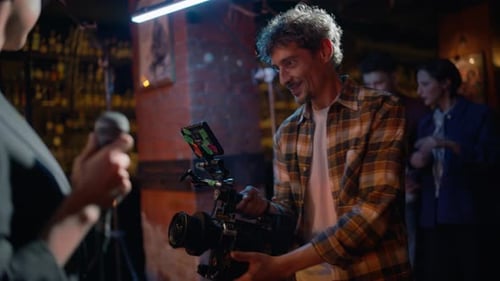 Enthusiastic Videographer Recording Rock Performance in Night Club Stage Closeup