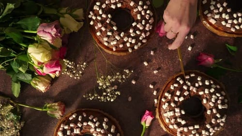 Hand Cutting Donut With Marshmallow Topping on Decorative Bakery Table