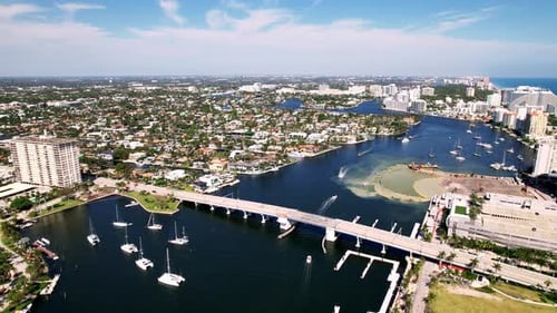 Luftaufnahme von Brücke und Stadtstrand und Sand mit ruhigem Wasser, Gebäude an der Seite, blaues Wasser, blau