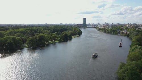 4k drone moving down and forward over the spree river with treptower park and the allianz building i