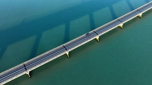 Brücke über türkisfarbenes Wasser Beeindruckende urbane Infrastruktur Symmetrische Linien und Schatten auf dem Meer