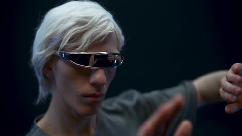 Young Man Wears Futuristic Glasses Gesturing with Hands