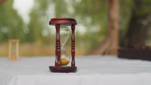 Wooden Hourglasses with Sand Stand on Table in Yard