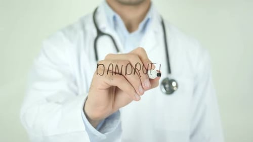 Doctor Writes Dandruff on Glass for Medical Concept