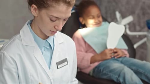 Portrait of Female Dentist with Child Patient at Dental Office