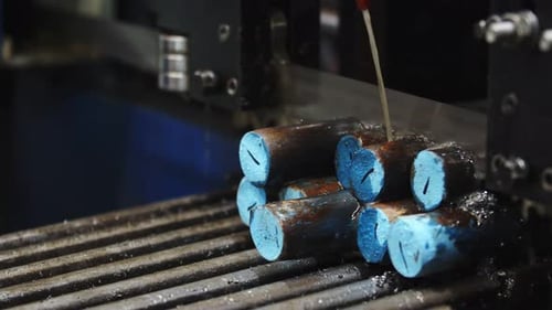 Moving Band Saw Simultaneously Cutting Off with Pouring Over Coolant a Few Metal Bars Stacked on Top