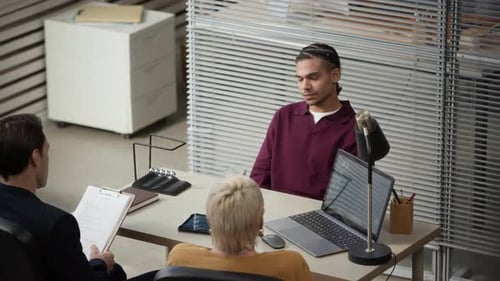 Junger Afroamerikaner beantwortet Fragen während des Vorstellungsgesprächs im Büro