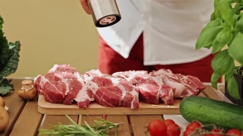 Closeup of a Chef's Hand Grinding Black Pepper on the Delicious and Juicy Meat Outdoor Restaurant