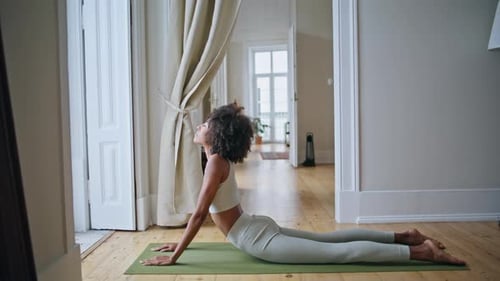 Woman Doing Yoga Exercise on Mat Indoors