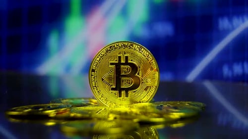 Close up of Golden Bitcoin with Financial Data