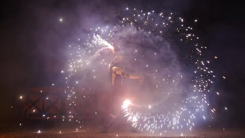 Performer Creating Sparks with Pyrotechnics at Night