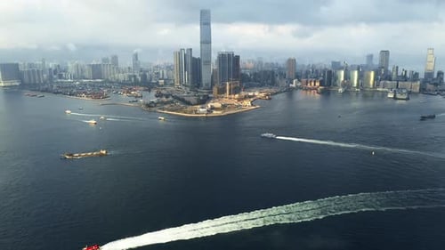 Drone, ocean and boat with skyscraper in city of Hong Kong with clouds, building