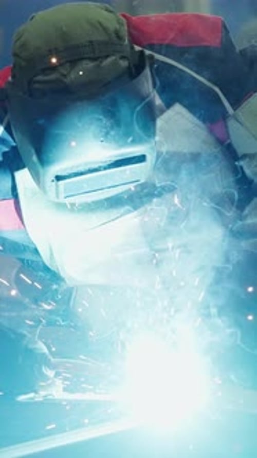 Welder Creating Sparks at Workshop During Evening Hours