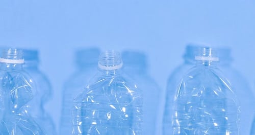 Close Up Video of Plastic Bottles Isolated on Blue Background Recycle Waste Management Video Concept
