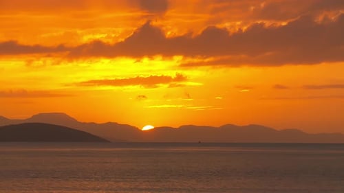 sunset, sea, mountains and moving clouds.