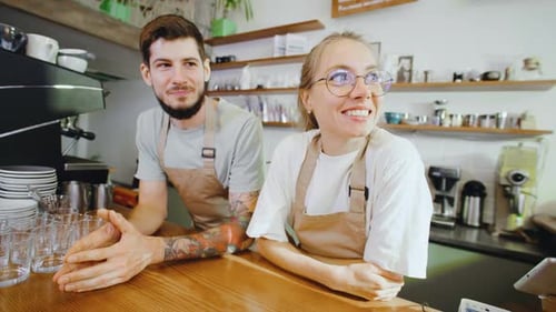 In a Charming Coffee Shop Two Baristas Share a Delightful and Lighthearted Moment Behind the Counter