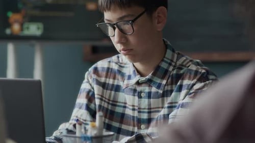 Asiatischer Schüler lernt Programmieren im Unterricht