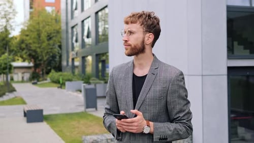 Young Man Texting Messages Chatting Tapping Scrolling on Smartphone Outdoor