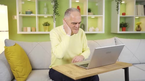 Senior Adult Typing on Laptop at Home